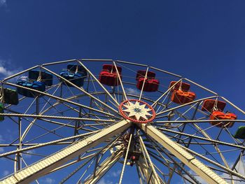 Low angle view of ferris wheel against blue sky