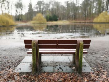 Empty benches in park by lake