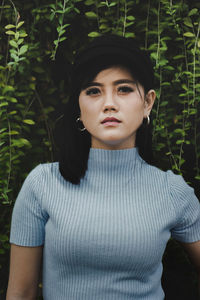 Portrait of beautiful woman standing against plants