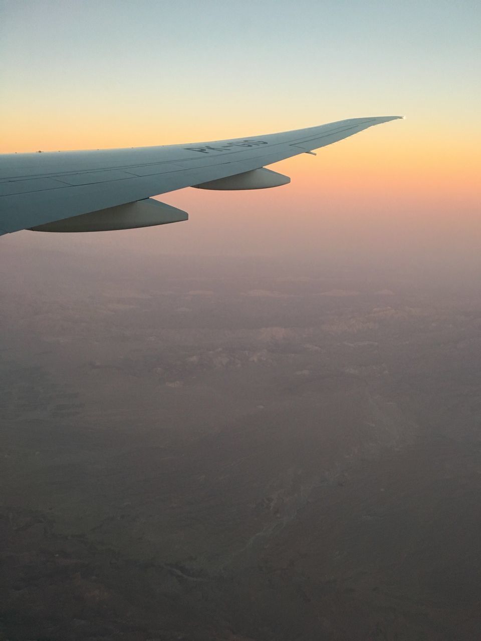 AIRPLANE WING AGAINST SKY DURING SUNSET