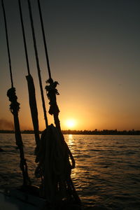 Silhouette boat in sea against clear sky during sunset