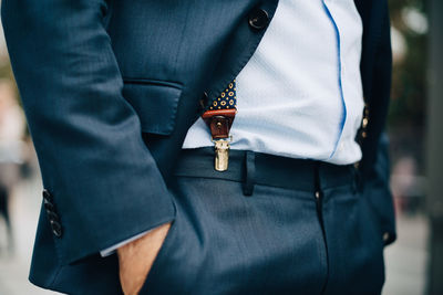 Midsection of businessman standing with hand in pocket