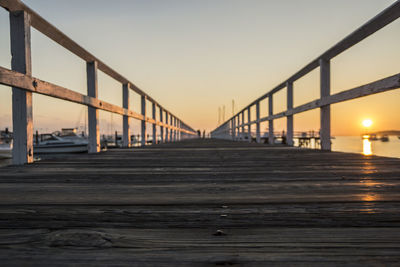 Suspension bridge over river against sky during sunset