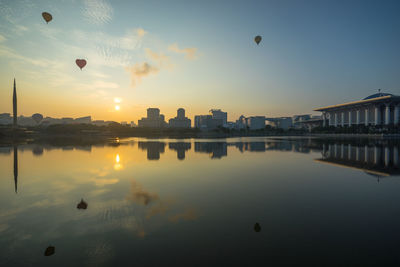 Reflection of buildings in lake during sunset