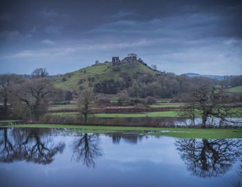 Scenic view of lake by trees against sky