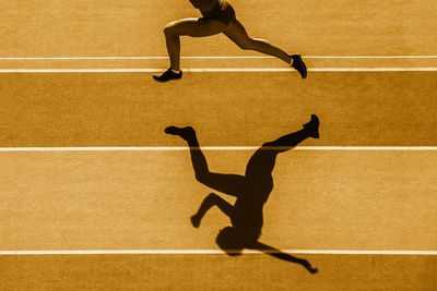 Low section of man running on track