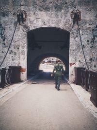 Rear view of man standing at archway