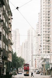 Traffic on city street by buildings against sky
