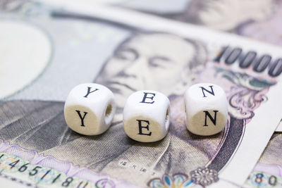 Close-up of beads with yen text on paper currency