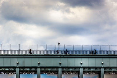 People walking on bridge against sky
