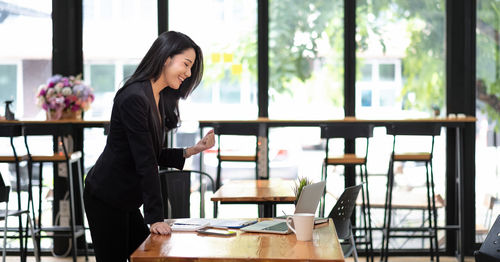 Woman standing on table at home