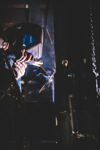 Rear view of young woman holding camera