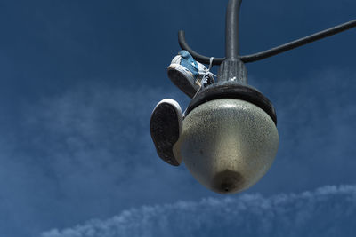 Low angle view of chain hanging on snow against blue sky