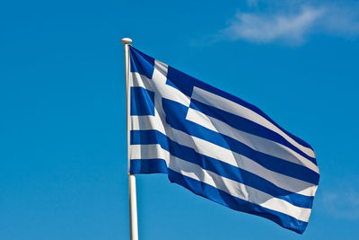 Low angle view of flag against blue sky