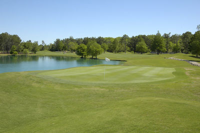 Scenic view of golf course against sky