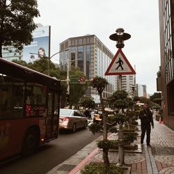 People on road against buildings in city