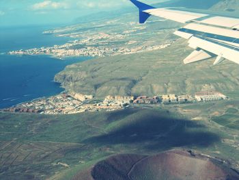 Aerial view of landscape by sea against sky