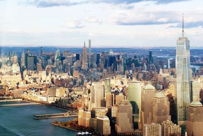 Aerial view of cityscape against cloudy sky