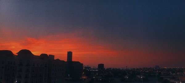 Silhouette buildings against sky during sunset