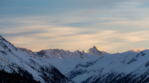 Scenic view of snowcapped mountains against sky during sunset