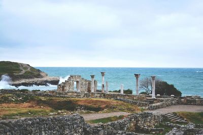 Scenic view of sea by cityscape against sky