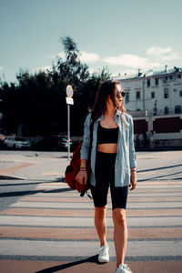 Full length of woman walking on road against sky