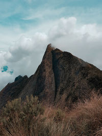 Low angle view of rocks on mountain against sky