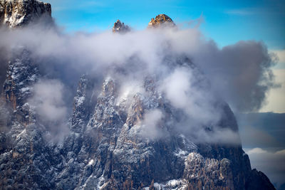 Firework display over mountains against sky