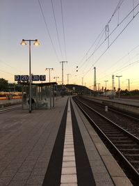 Railroad platform against clear sky during sunset