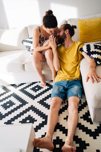 Young couple sitting on sofa at home