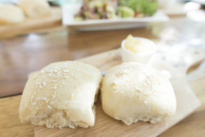 High angle view of bread with butter on cutting board at table