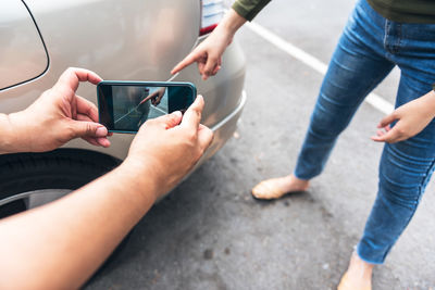 Low section of man using mobile phone