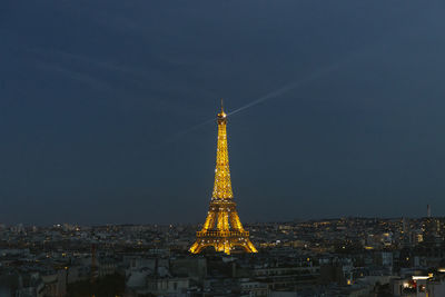 Illuminated buildings in city against sky at night