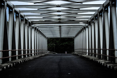 Empty footbridge amidst buildings