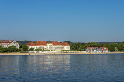 Buildings at waterfront against blue sky