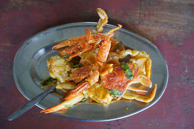 Crab with salted-egg sauce served in tin plate on the table