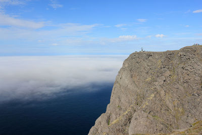 Rock formations by sea against sky