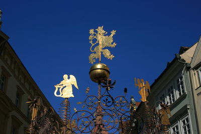 Low angle view of street light by building against clear blue sky