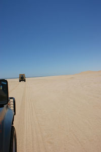 Cars on road against clear blue sky