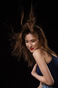 Portrait of beautiful woman against black background