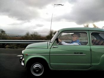 Car on road against cloudy sky