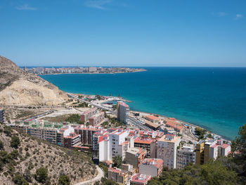 High angle view of townscape by sea against sky