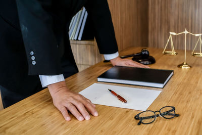 Midsection of man using mobile phone on table