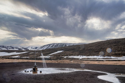 View of hot shower from geothermal power at krafla in valley against cloudy sky