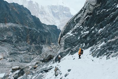 People walking on snowcapped mountains during winter