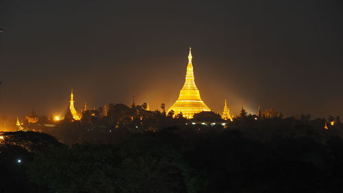 Illuminated shwedagon pagoda against clear sky at night
