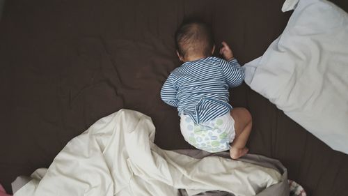 High angle view of baby sleeping on bed