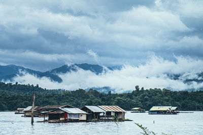 Houses on building by mountains against sky