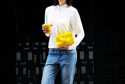 Midsection of man holding ice cream standing outdoors