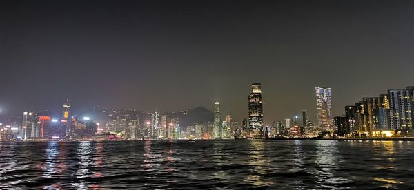 Illuminated buildings in city against sky at night